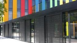 Farbige Glaspaneele gliedern im Wechsel mit schwarz getönten Fensterflächen die Glas- fassade des neuen Verwaltungs- und Service- zentrums der EPFL in Lausanne. (Foto: GKD)
